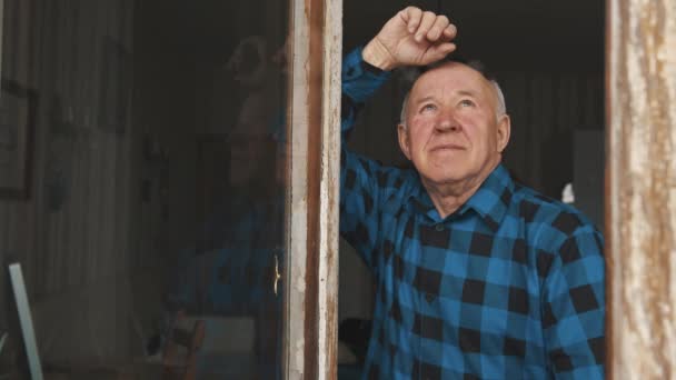 Senior European man looking up through the window medium closeup indoor senior people concept — Stock video