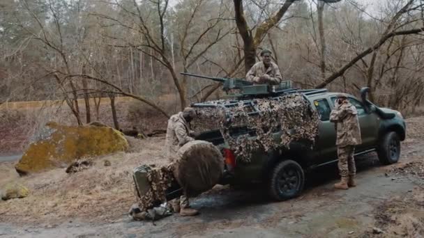 Vollständige Außenaufnahme eines Militärfahrzeugs mit Schusswaffe auf dem Dach, das von Soldaten benutzt wird. — Stockvideo