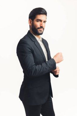 Çekici Latin bir adam takım elbise giyiyor. Düğme daha hızlı ve kameraya dikey bakıyor. İzole edilmiş beyaz arka plan.