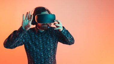 Beyaz sakallı bir girişimcinin sanal gerçeklik gözlüğü setini ilk kez denerken çekilen kapalı stüdyo fotoğrafı. Yenilik ve teknoloji kavramı.