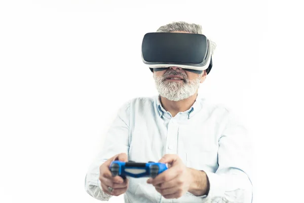 Blanke man van middelbare leeftijd met zilvergrijs haar draagt Virtual Reality Googles en houdt een blauwe Gamepad vast. geïsoleerd op wit — Stockfoto