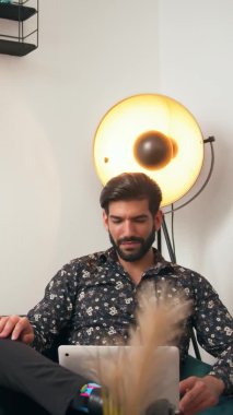 Mutlu Latin Amerikalı adam, ofisinde dikey bir şekilde videoyla konuşuyor ve gülüyor.