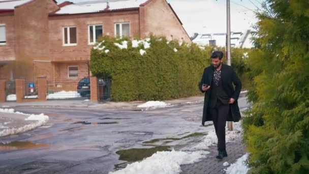 Bonito latino barbudo homem andando na rua enquanto fala em seu telefone — Vídeo de Stock