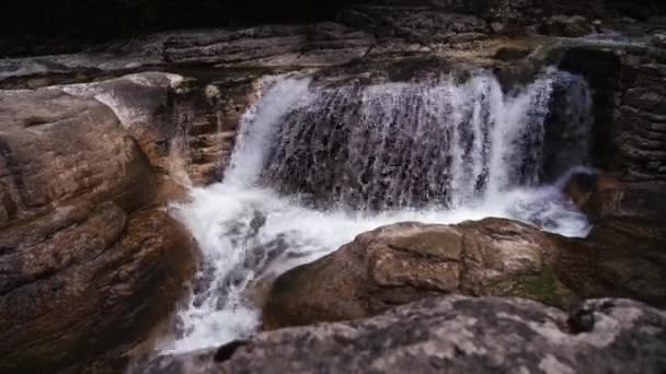 山の上を流れる流れの速い滝のビデオです — ストック動画