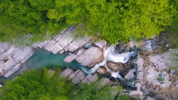 Красивый маленький чистый водопад с большими камнями весной — стоковое видео