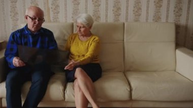 Yaşlı adam röntgen sonuçlarını evde karısına gösteriyor. Yüksek kalite 4k görüntü