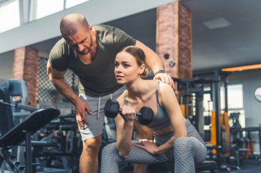Spor salonunda halterle spor yapan bir kadın. Sağlıklı yaşam tarzı ve egzersiz. Yüksek kalite fotoğraf