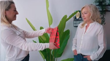 Senin için bir şeyim var. Sarışın kadın, arkadaşının orta boy içkisine hediye veriyor. Yüksek kalite 4k görüntü