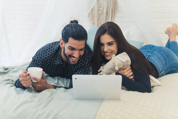 Jong stel kijken films samen op een laptop, vrije tijd doorbrengen samen op het bed, rusten na de harde dag — Stockfoto