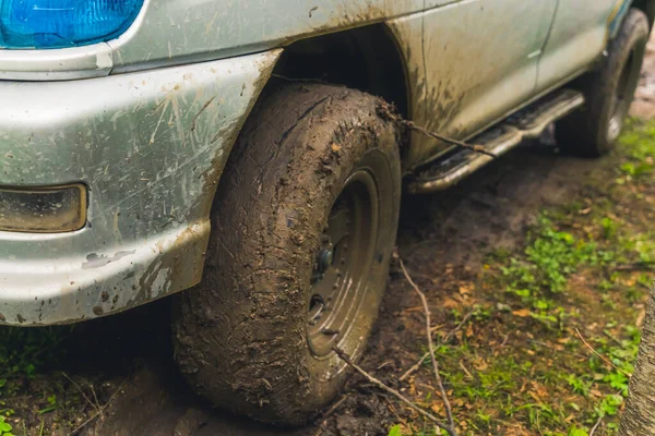 Vista de cerca de una rueda de coche en la carretera fangosa — Foto de Stock