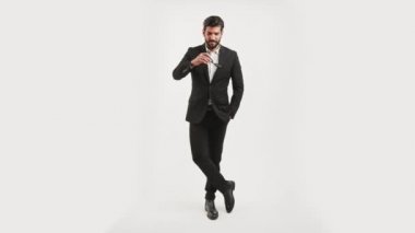 Yakışıklı, kendine güvenen, zarif bir takım elbise giyen ve güneş gözlüğü takan başarılı bir adamın beyaz arka planının geniş bir çekimi. Uzayı kopyala Yüksek kalite 4k görüntü