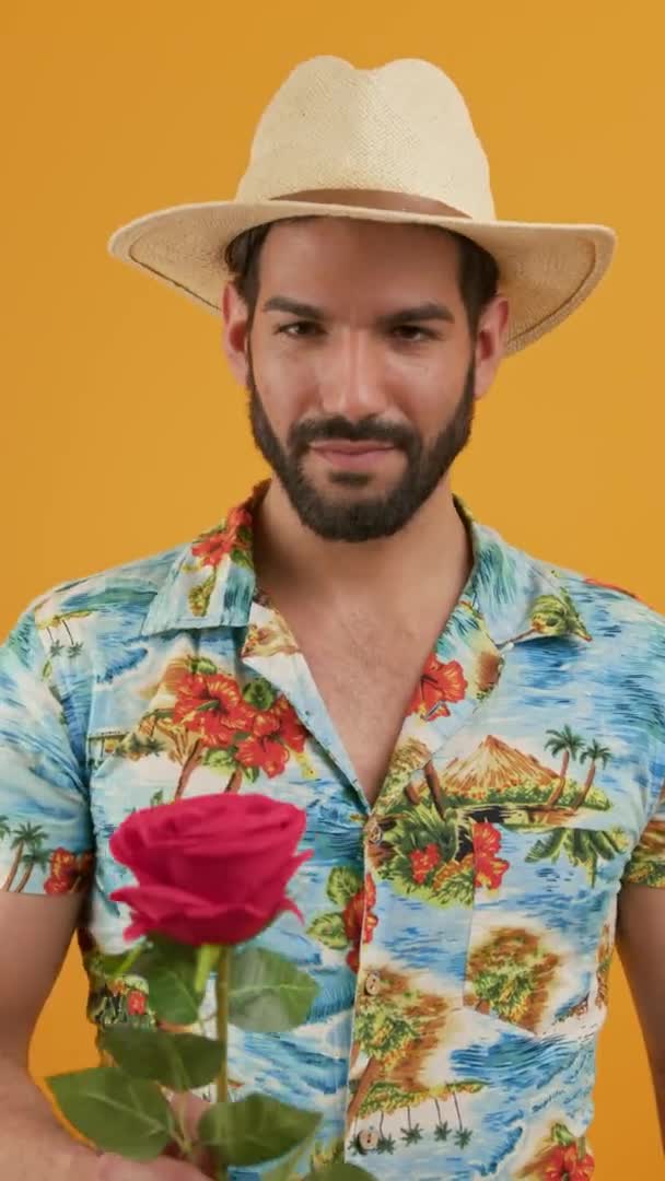 身穿衬衫头戴帽子 留着大胡子的拉丁男子在摄像机前献上一朵红玫瑰 高质量的4K镜头 — 图库视频影像