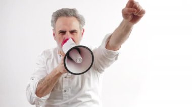 Protesto konsepti. Kafkasyalı yaşlı, gri saçlı adam hoparlörden bağırıyor ve yumruğunu havaya fırlatıyor. Beyaz arka planda izole edilmiş. Yüksek kalite 4k görüntü