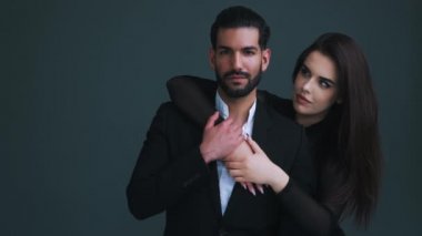 Profesyonel heteroseksüel bir çiftin resmi. Koyu renk saçlı Kübalı genç girişimci uzun saçlı kız arkadaşına güzel bir gülümsemeyle sarılıyor. Yüksek kalite 4k