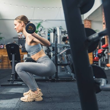 Spor salonunda ağırlık kaldıran sporcu bir kadın, dikey. Yüksek kalite fotoğraf