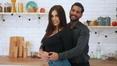 Orta yaşlı, çok ırklı, siyah giyinmiş, tezahürat yapan, mutfakta ayakta duran evli bir çiftin kapalı çekimleri. Yüksek kalite 4k görüntü