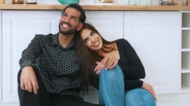 Güzel, heteroseksüel bir çift mutfakta oturmuş gülümsüyor. Birlikte yaşama kavramı. Genç eşler. - Evet. Yüksek kalite 4k görüntü