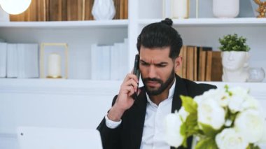 Zarif, seksi, orta yaşlı, pahalı takım elbiseli Kübalı girişimci parlak modern ofisinde otururken bilgisayarına bakıyor. - Evet. Yüksek kalite 4k görüntü