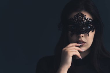 Gizemli baştan çıkarıcı kadın konsepti. 20 'li ya da 30' lu yaşlarda, kimliğini gizleyen ve dudaklarına dokunan siyah dantelli göz maskesi takan güzel bir Avrupalı kızın stüdyo portresi. Yüksek kalite fotoğraf