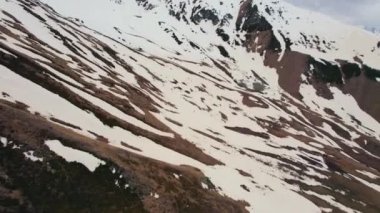 Hava aracı dağ manzaralı. Dağda kar ve gri zemin görülebilir. Yüksek kalite 4k görüntü