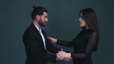 İki tutkulu insan, siyah kıyafetler giyip gri arka planda dans ediyorlar. Dans bir yaşam tarzıdır. Yüksek kalite 4k görüntü