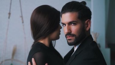 Seksi sakallı, baştan çıkarıcı, siyah saçlı, boyun eğen, uzun saçlı kadın ortağının kapalı bir portresi. Yüksek kalite 4k görüntü