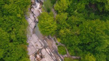 Ormanla çevrili küçük bir şelalenin manzaralı insansız hava aracı görüntüsü. Yüksek kalite 4k görüntü