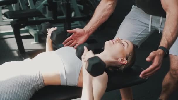 Europeiska Blonda Idrottskvinna Lyfta Hantlar Ett Gym Skallig Kroppsbyggare Som — Stockvideo