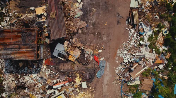 Aerial view of an unorganized messy garbage dump with pieces of furniture and big metal rusty containers. High quality photo