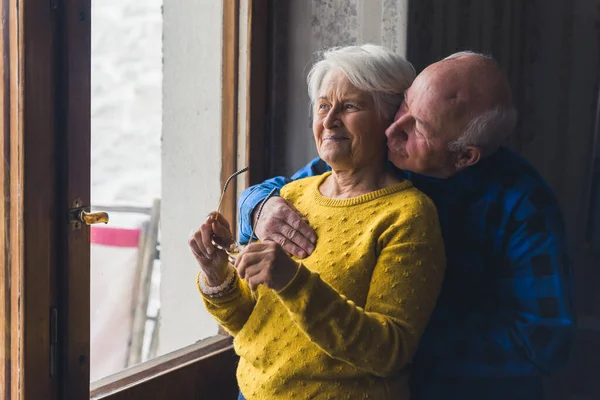 ウィンドウドアの近くに立っている素敵な陽気なシニア白人カップルと外側の中規模の撮影室内の高齢者の愛の概念 高品質の写真 — ストック写真