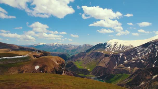 Панорамный Вид Горы Казбеги Зеленую Долину Пересеченную Дорогами Голубым Озером — стоковое видео