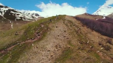 Gürcistan, Kazbegi 'deki tepenin üstünde yürüyen insanların hava görüntüsü. Yüksek kalite 4k görüntü