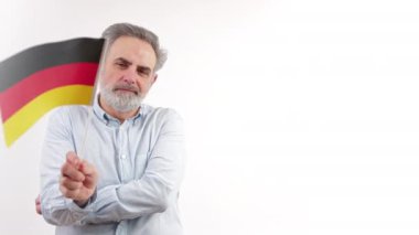 Beyaz saçlı, gri tişörtlü kıdemli adam. El ele tutuşan Alman bayrağı. Fotokopi stüdyosunun orta boy fotoğrafını çekti. Yüksek kalite 4k görüntü