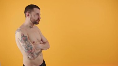 30 'lu yaşlardaki beyaz adam kollarını kavuşturup izole edilmiş fotokopi stüdyosu fotoğraflarına bakıyor. Yüksek kalite 4k görüntü