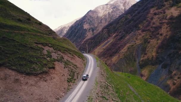 Необычное Путешествие Воздуха Одинокая Машина Едет Гравийной Дороге Между Горами — стоковое видео