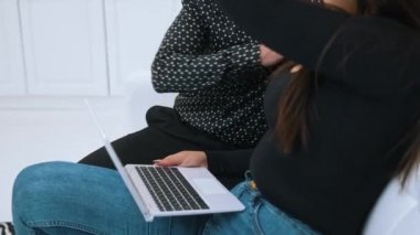 Şirin heteroseksüel çift kanepede otururken dizüstü bilgisayarlarıyla alışveriş yapıyor. Modern eşler konsepti. Yüksek kalite 4k görüntü