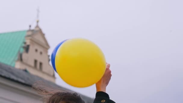 与乌克兰站在一起 支持和平的表现 白种人拿着两个乌克兰国旗色的气球 黄色和深蓝色 深蓝色的气球像欧洲的星条旗 高质量的 — 图库视频影像