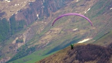 Gürcistan dağlarının üzerinden yavaşça paraşütle atlıyorlar. Alışılmadık hobiler. Yüksek kalite 4k görüntü