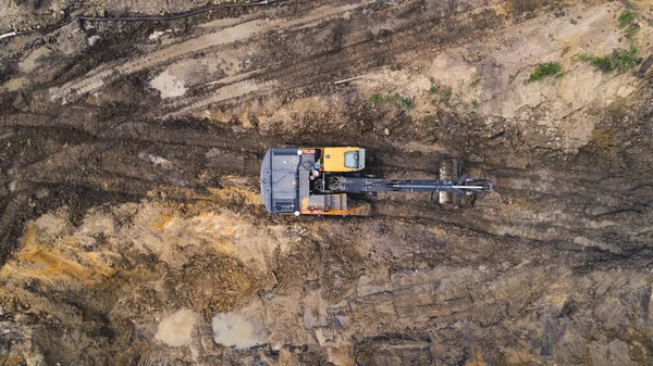 Drone outdoor shot of a professional heavy machinery in the sand during works at a road construction site of a new highway. High quality photo