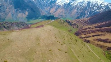 Arka planda Kazbegi, Georgia 'daki Kafkas dağlarının insansız hava aracı görüntüleri. Yüksek kalite 4k görüntü