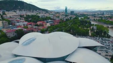 18.05.2022, Tiflis, Georgia. Tiflis 'i Adalet Evi' yle birlikte şehrin etrafını saran binalar ve tepelerle gösteren insansız hava aracı görüntüleri. Yüksek kalite 4k görüntü