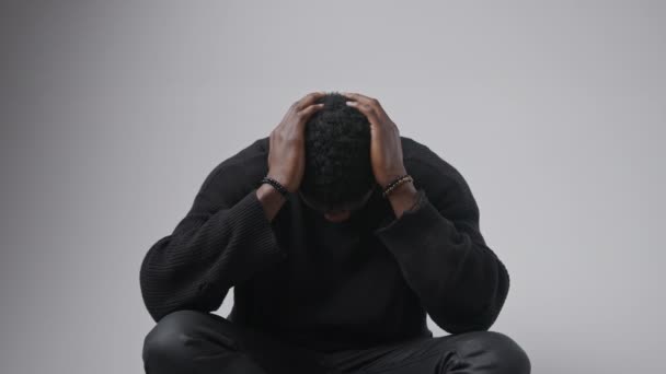 アフリカ系アメリカ人の男性は 頭に手を置いて頭を下げ続け 祈りのジェスチャーを作り 灰色の背景を孤立させます 高品質4K映像 — ストック動画