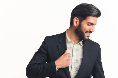 Latin işadamı poz veriyor ve ceketini ayarlıyor kameradan uzağa bakıyor, orta boy beyaz arka plan. Yüksek kalite fotoğraf