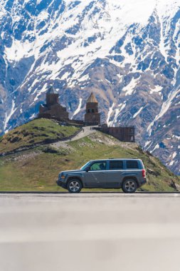 Gürcistan, Kazbegi 'deki Gergeti Trinity Kilisesi yolunda. Dikey. Yüksek kalite fotoğraf