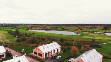 Güzel, sakin ve zengin bir manzaranın havadan görünüşü, büyük modern evler, golf oynayan insanlar ve temiz küçük göletler. Yüksek kalite 4k görüntü