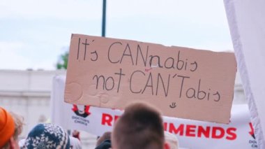 Bu Cannabis, CanTabis değil. Şehir merkezinde yapılan yıllık yürüyüş sırasında genç bir yasal kenevir destekçisinin yaratıcı el yapımı posteri. Yüksek kalite 4k görüntü