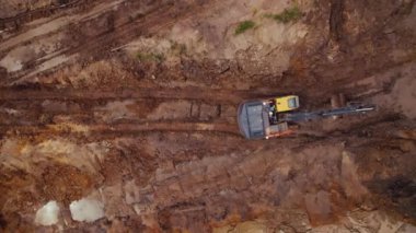 Çamurlu bir inşaat alanında çalışan bir inşaat makinesinin insansız hava görüntüsü. Yeni otoban yapımı. Yüksek kalite 4k görüntü