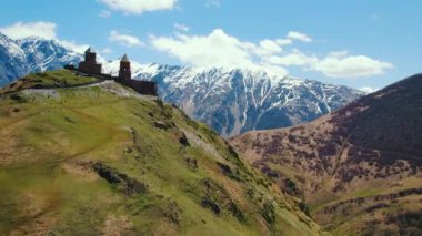 Gergeti Trinity Kilisesi 'nin güneşli bir havada Kafkaslar' la çekilmiş görüntüsü, Kazbegi, Georgia. Yüksek kalite 4k görüntü