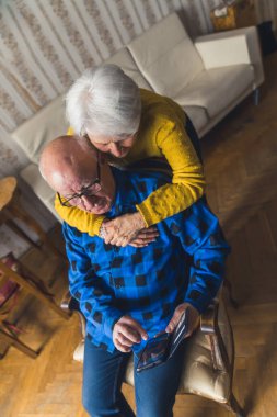 Kafkasyalı şirin bir çift ev ortamında akıllı telefon kullanıyor modern teknolojileri ve kıdem kavramını dikey çekimde kapatıyorlar. Yüksek kalite fotoğraf