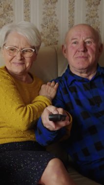 Son sınıf çifti, evde orta ölçekli komik bir şey izliyorlar. Ev içi video çekimleri, yaşlılar konsepti. Yüksek kalite 4k görüntü